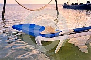 Lounge Chair in the Ocean with Hat Resting on Top
