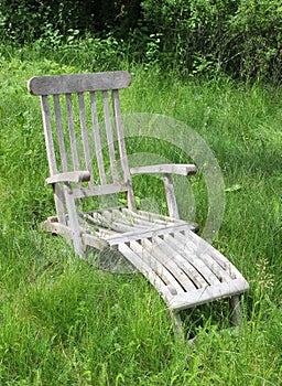 Lounge chair in wildly grown field of grass. photo