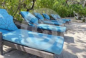 Lounge chairs or beach chairs on white sand beach in hot summer day in luxury tropical hotel