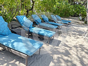 Lounge chairs or beach chairs on white sand beach in hot summer day in luxury tropical hotel