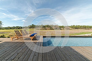 Lounge chairs in modern villa pool