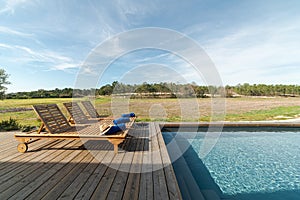 Lounge chairs in modern villa pool