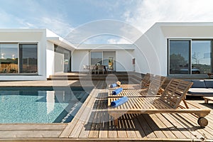 Lounge chairs in modern villa pool