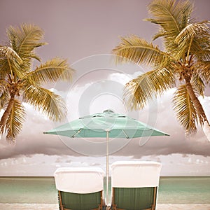 Lounge chairs and umbrella at a tropical paradise beach