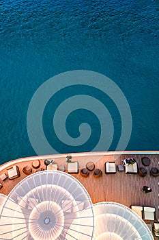 Lounge promenade deck on cruise ship. Interior of luxury cruise restaurant with tables and armchair in sunset at sea