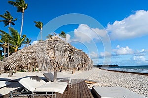 Lounger on beach, with tropical sea as background under umbrella