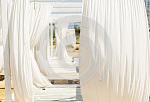 Lounger bed with white curtins on the beach for a relaxing getaway.