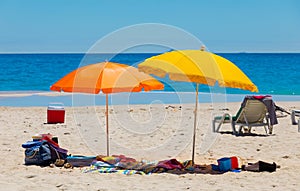 Lounger chairs and parasol umbrellas on sandy beach in Cape Town