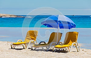 Lounger chairs and parasol umbrellas on sandy beach in Cape Town