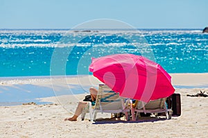 Lounger chairs and parasol umbrellas on sandy beach in Cape Town