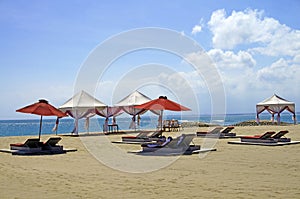 Lounger chairs and parasols on a sand beach in Bali