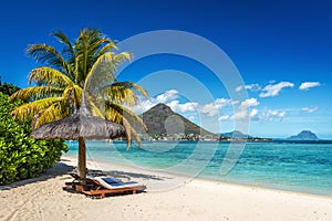 Loungers and umbrella on tropical beach in Mauritius