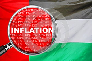 Loupe focused on the word inflation on flag of United Arab Emirates background. Inflation, tax, financial concept in United Arab