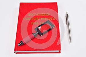 Loupe lies on the red the provider directory next to the pen