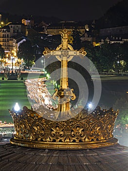 LOURDES, FRANCE - SEPTEMBER 14 2019: Cross in front of the candle procession, every night in Lourdes, France, Europe