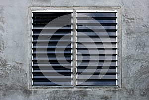Louver window on gray concrete wall