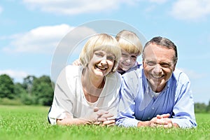 Lovable family of three lying in the park
