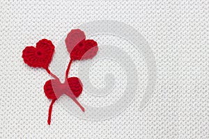 Love affair, love story. Two red crochet wool hearts and ribbon on white crochet background. The concept for 14 February, romantic