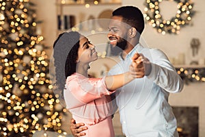 Smiling black man dancing with his pretty woman photo