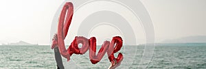 Love air balloon in woman hands at the sea or ocean coast, sandy shore, seascape , st valentine concept, fall in love