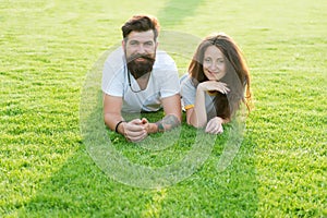 Love is in the air. Bearded man and sensual girl relax on green grass. Couple in love on summer landscape. Enjoying