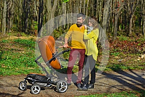 Love is in the air. Family couple stroll in park. Couple of woman and man walk with baby pram outdoor