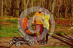 Love is in the air. Family couple stroll in park. Couple of woman and man walk with baby pram outdoor