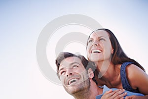 Love is in the air. A handsome man piggybacking his loving wife outdoors.