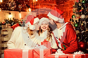 Love is in the air. small child and parents in santa hat. xmas gift boxes. Open present. family celebrate new year