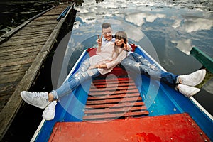 Love is all that matters. Top view of beautiful young couple taking selfie using smart phone while lying in the boat