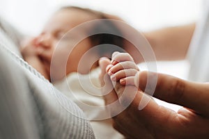 Love - baby holding fathers hand, white background. Little fingers