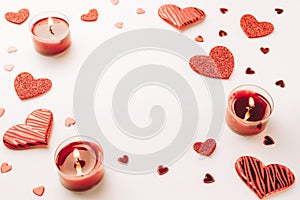 Love background: Valentines day red hearts, romantic gift box, candle on white table. Romantic message template with copy space
