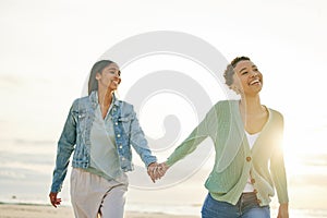 Love, beach and lesbian couple holding hands, walking together on sand and sunset holiday adventure. Lgbt women, bonding