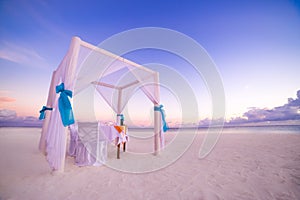 Love beach. Romantic beach dinner, white sand and white tent. Sunrise or sunset colors for couple and honeymoon background concept