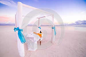 Love beach. Romantic beach dinner, white sand and white tent. Sunrise or sunset colors for couple and honeymoon background concept