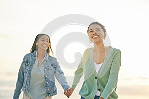 Love, beach and smile, lesbian couple holding hands and walking together on sunset holiday adventure. Lgbt women