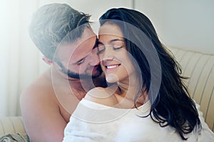 Love is a beautiful thing. a young couple enjoying a romantic moment on the sofa together in the morning.