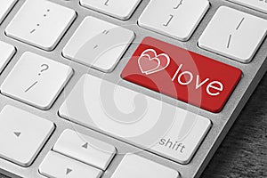 Love button on laptop keyboard, closeup. Online dating site