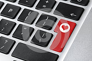 Love button on laptop keyboard, closeup. Online dating site