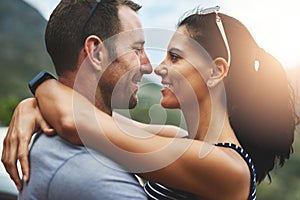 Love can be a simple smile. a young couple in a loving embrace outdoors.