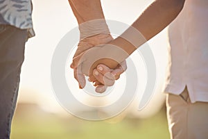 Love, care and couple holding hands in a park for support, help and hope together during summer. Back of man and woman