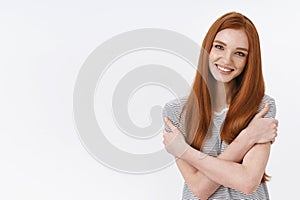 Love, care tenderness concept. Charming european redhead feminine young girl hugging herself hold shoulders tilting head
