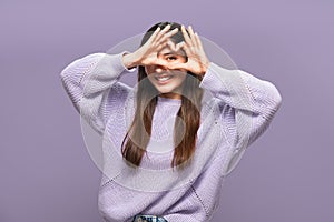 In love cheerful attractive multiracial woman in purple making a heart with her hands