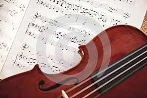 In love with classic music. Close up view of brown violin lying on music score sheet. Violin lessons