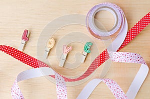 Love clips with cute ribbons on wooden background