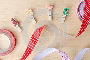 Love clips with cute ribbons on wooden background