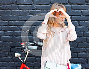 Love. Closeup portrait smiling happy young woman with long blon hair, making heart sign, symbol with hands. Positive human emotion