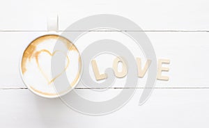 Love coffee cup of latte art with heart in white cup, romantic for valentine`s Day  on wood background