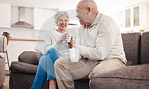 Love, coffee and elderly couple relax on a sofa, happy and laughing, talking and bonding in their home. Tea, chill and