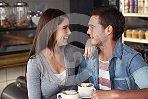 Love, conversation and happy couple in cafe, drinking coffee and bonding together on valentines day date. Smile, man and